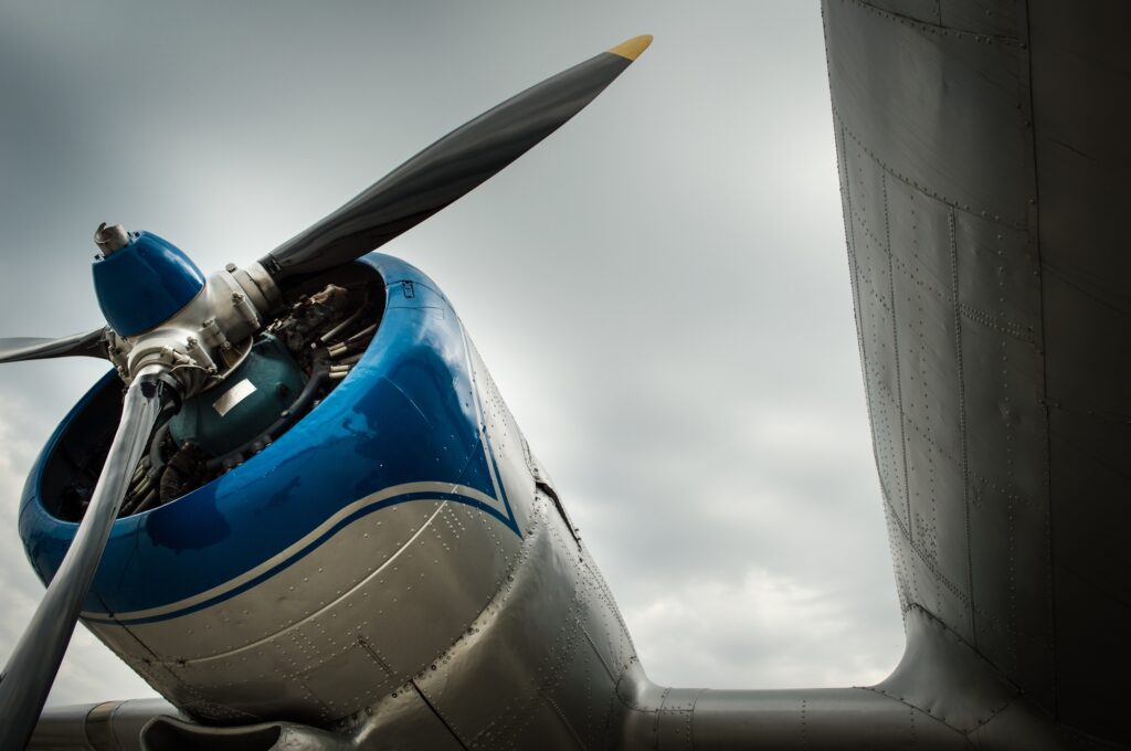 Low angle shot of the propeller on the wing of an airplane under the cloudy sky